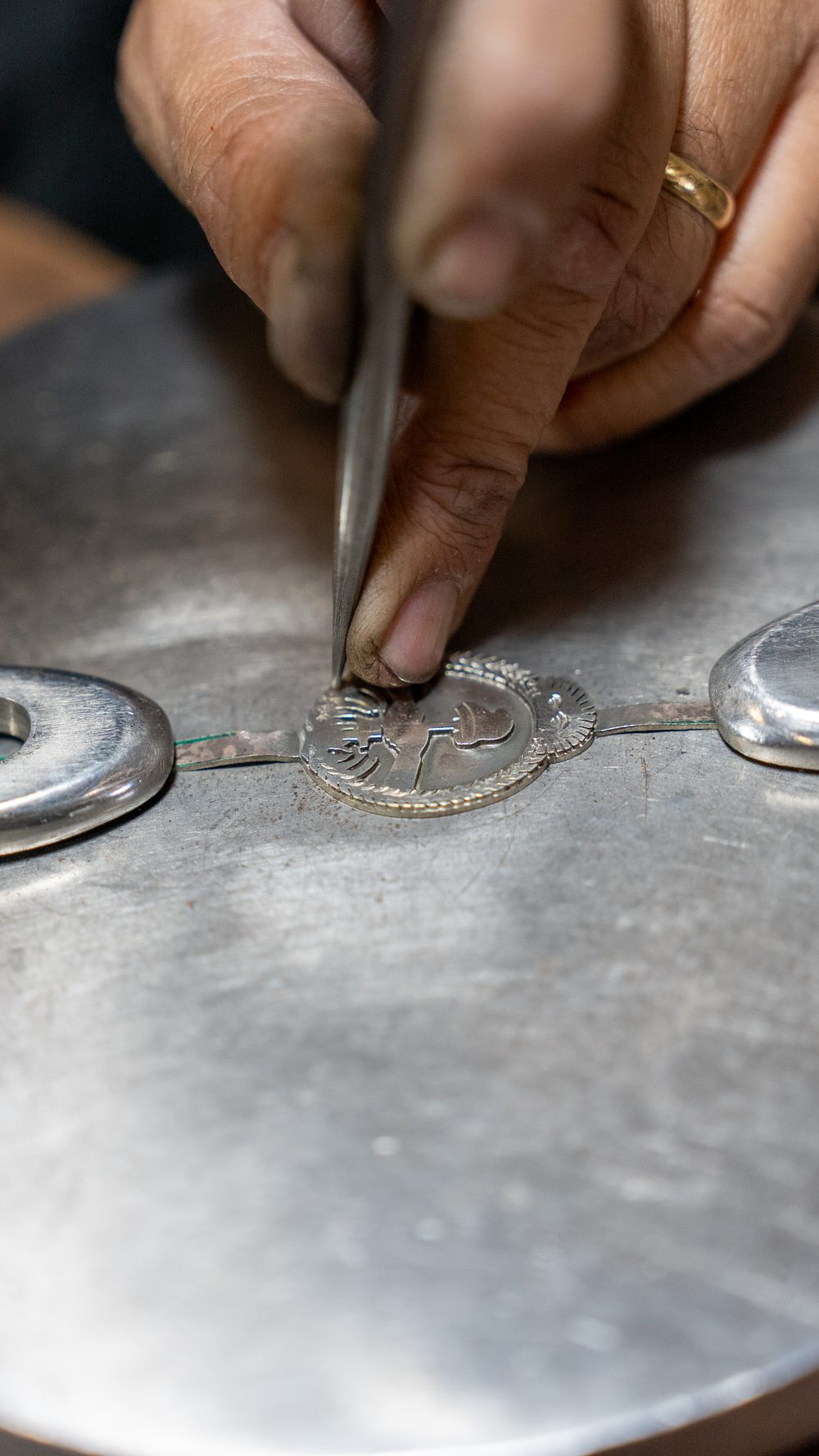 El buril trabajando los medallones de plata en el taller
